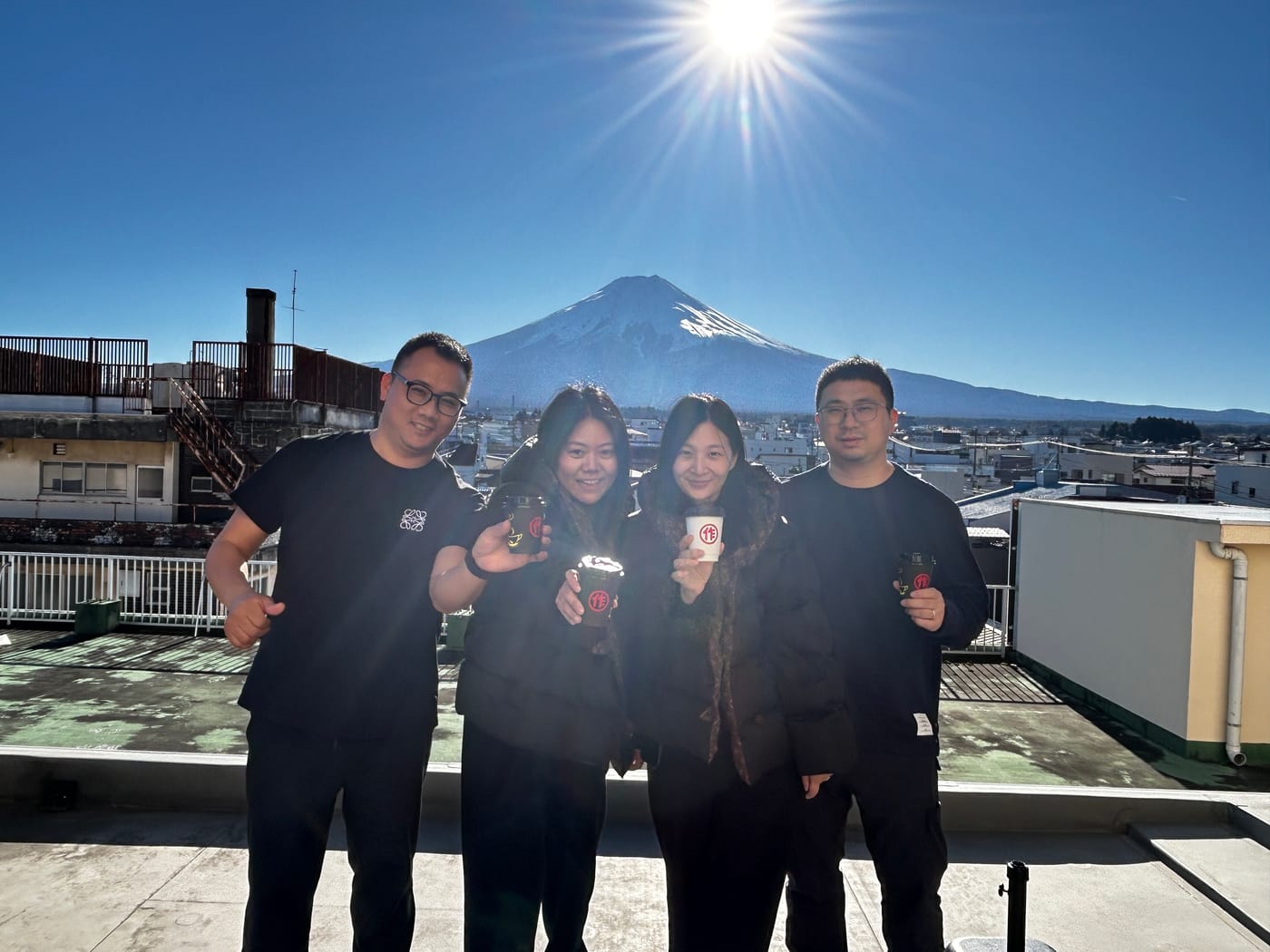 Guests with matcha cups and Mt. Fuji on the rooftop